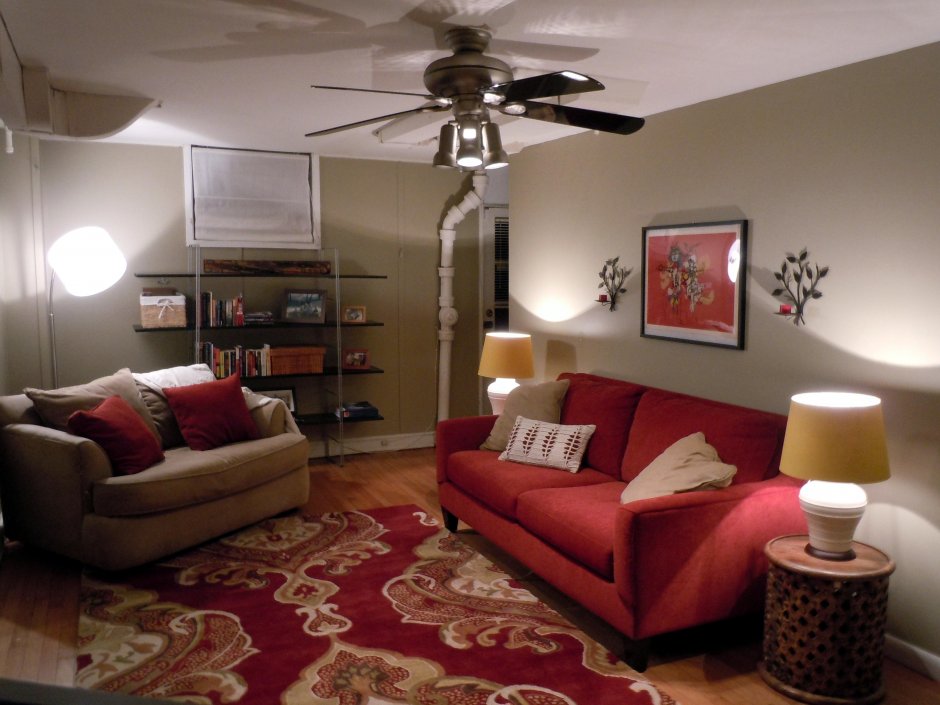 Простой интерьер гостиной с красным диваном