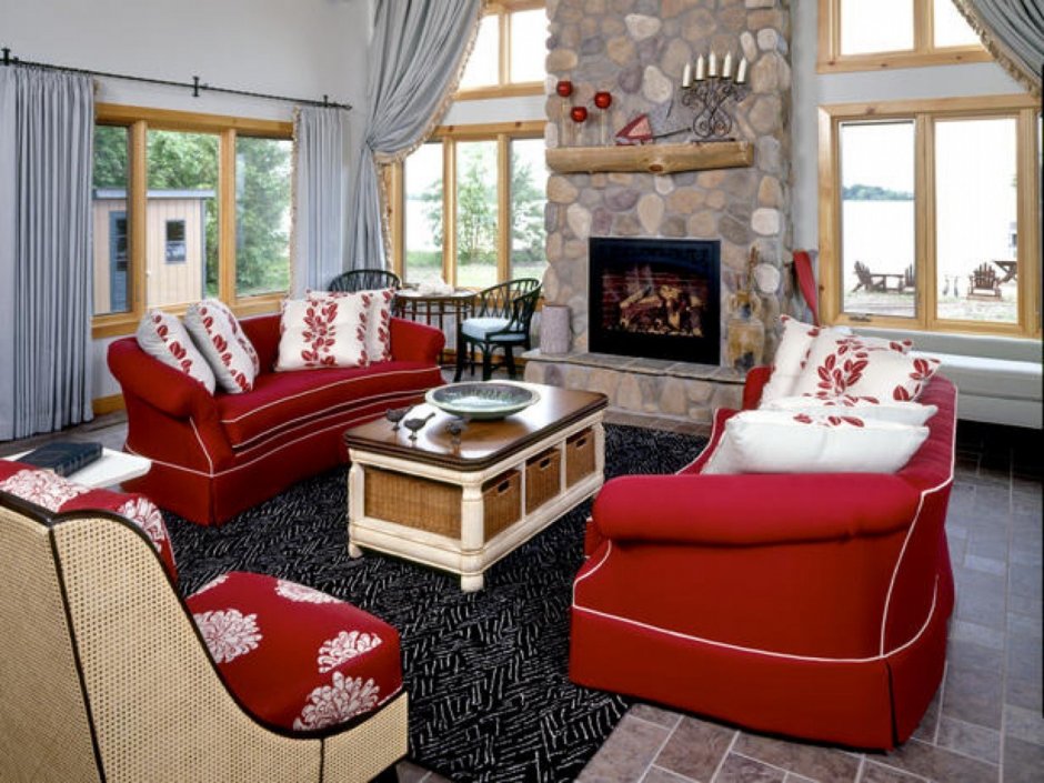 Красный диван в интерьере с камином