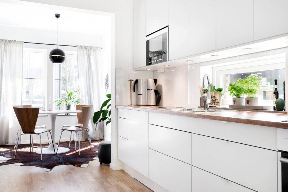 Интерьер белой кухни с деревянной столешницей в современном стиле