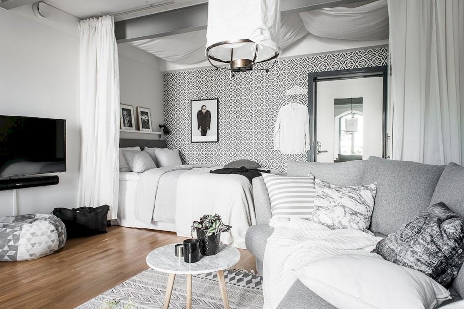Интерьер однокомнатной квартиры с кроватью в белых тонах