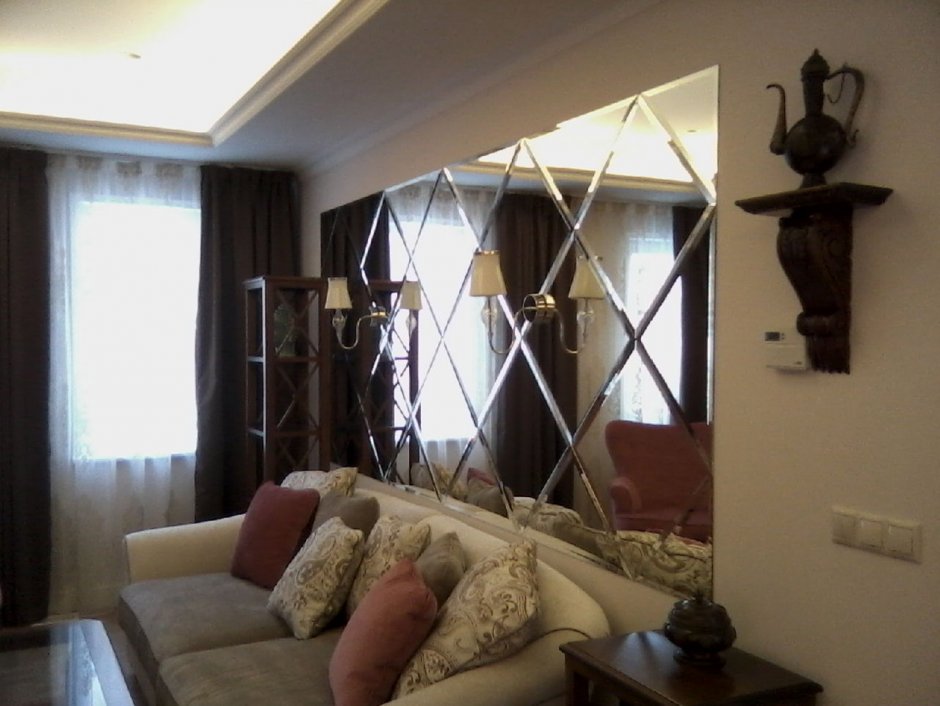 Зеркальная плитка в гостиной над диваном