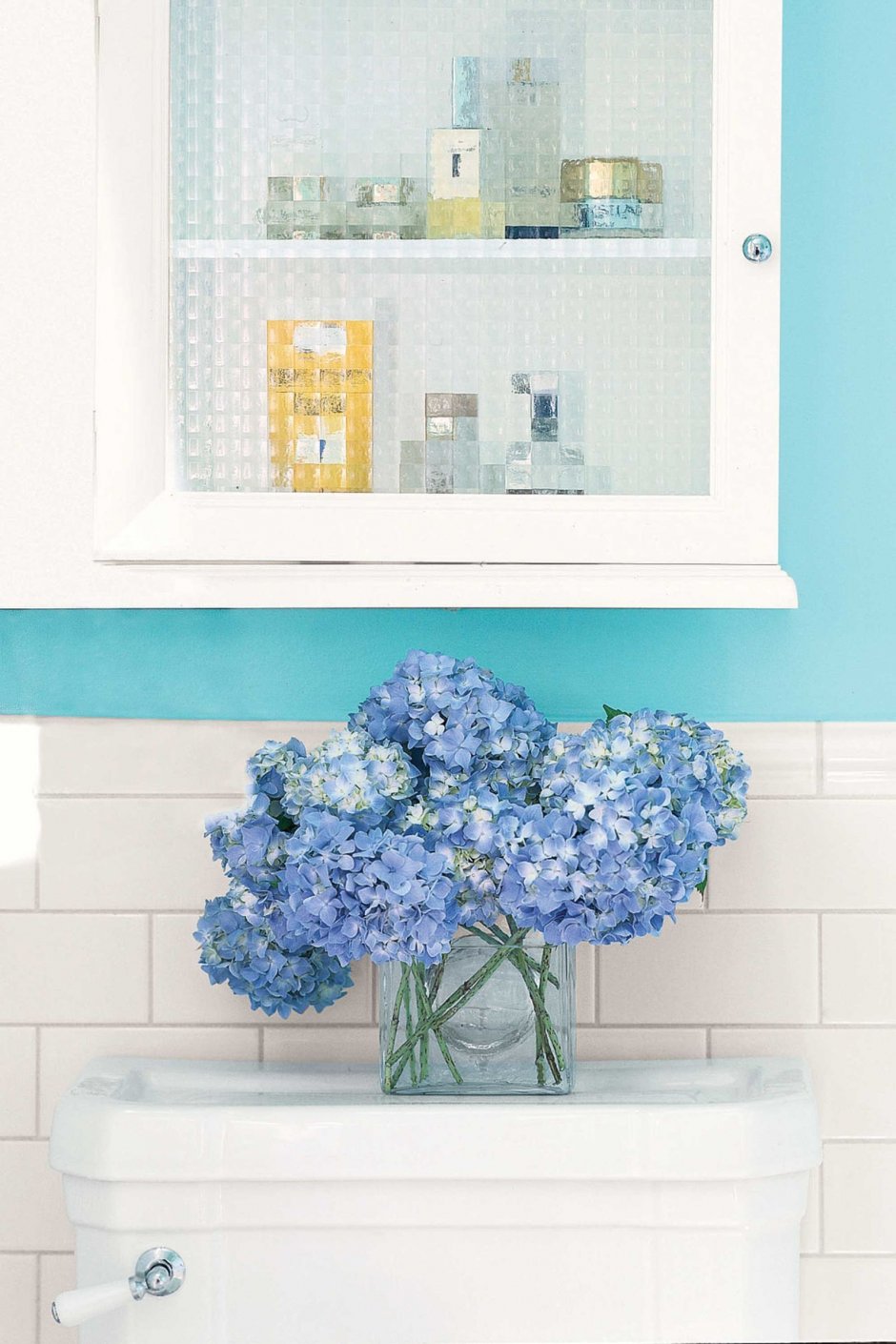 Голубые искусственные цветы в ванной комнате