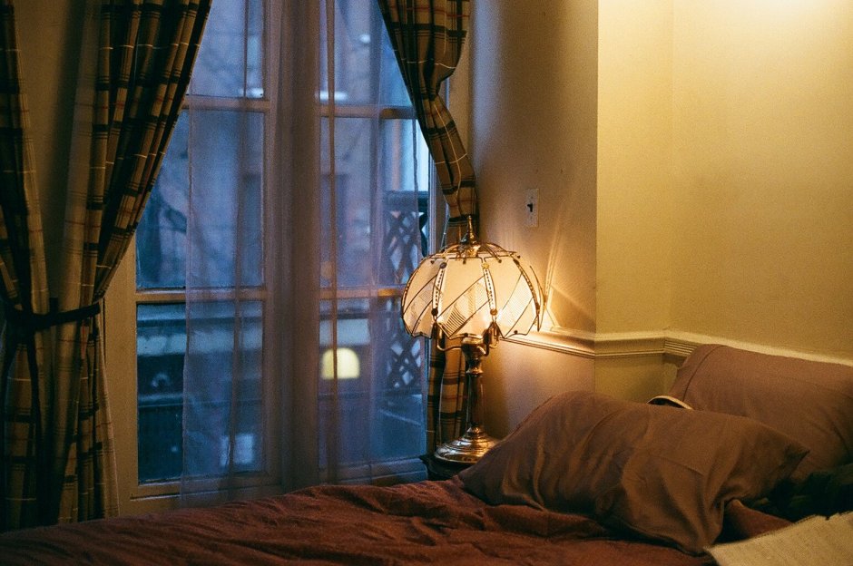 Кровать вечером у окна