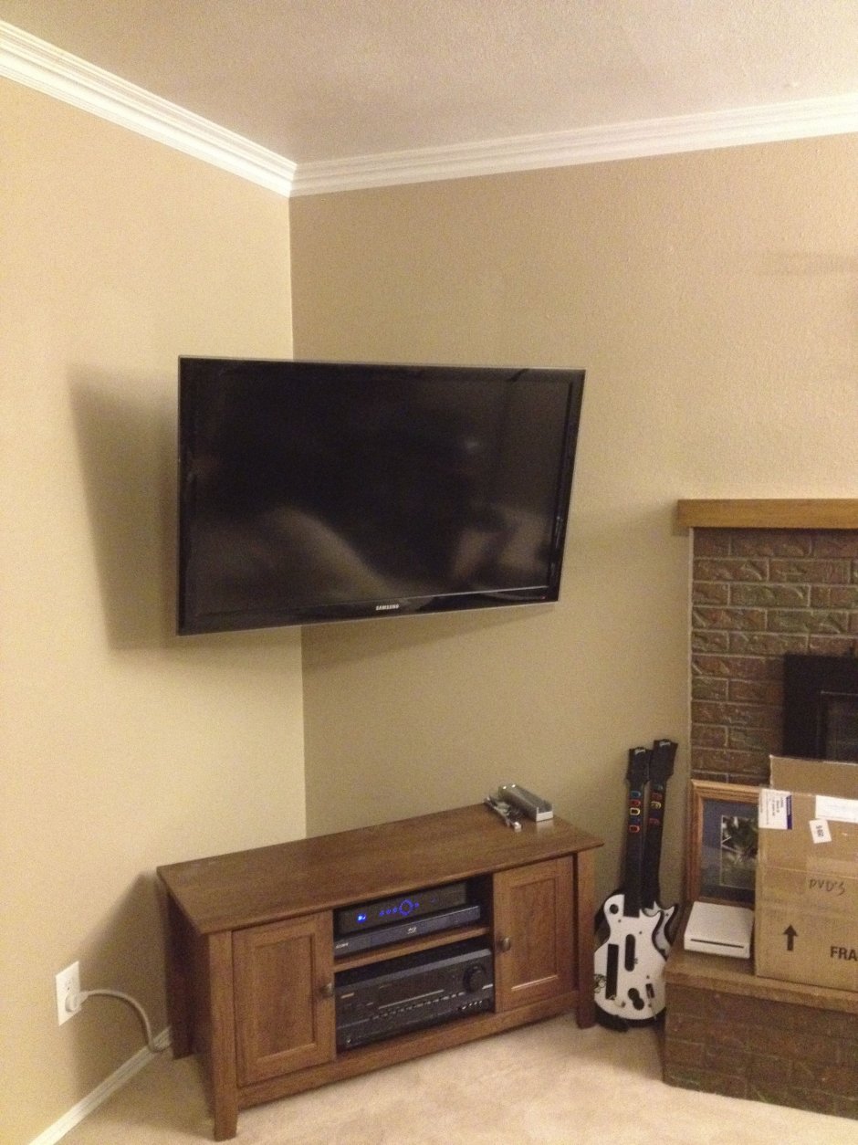 Телевизор в углу гостиной на кронштейне