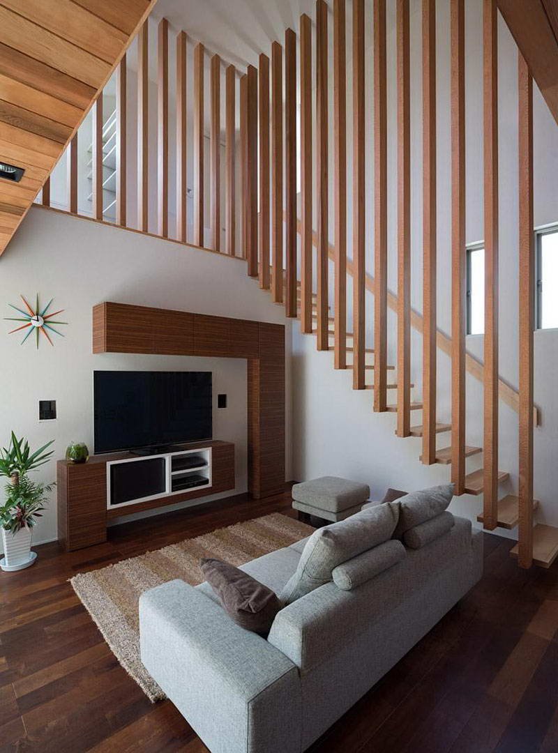 Интерьер гостиной с деревянной лестницей