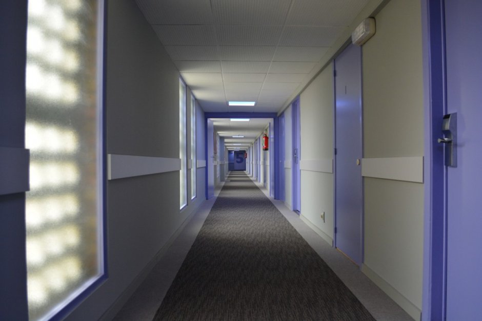 Длинный коридор с дверями в больнице