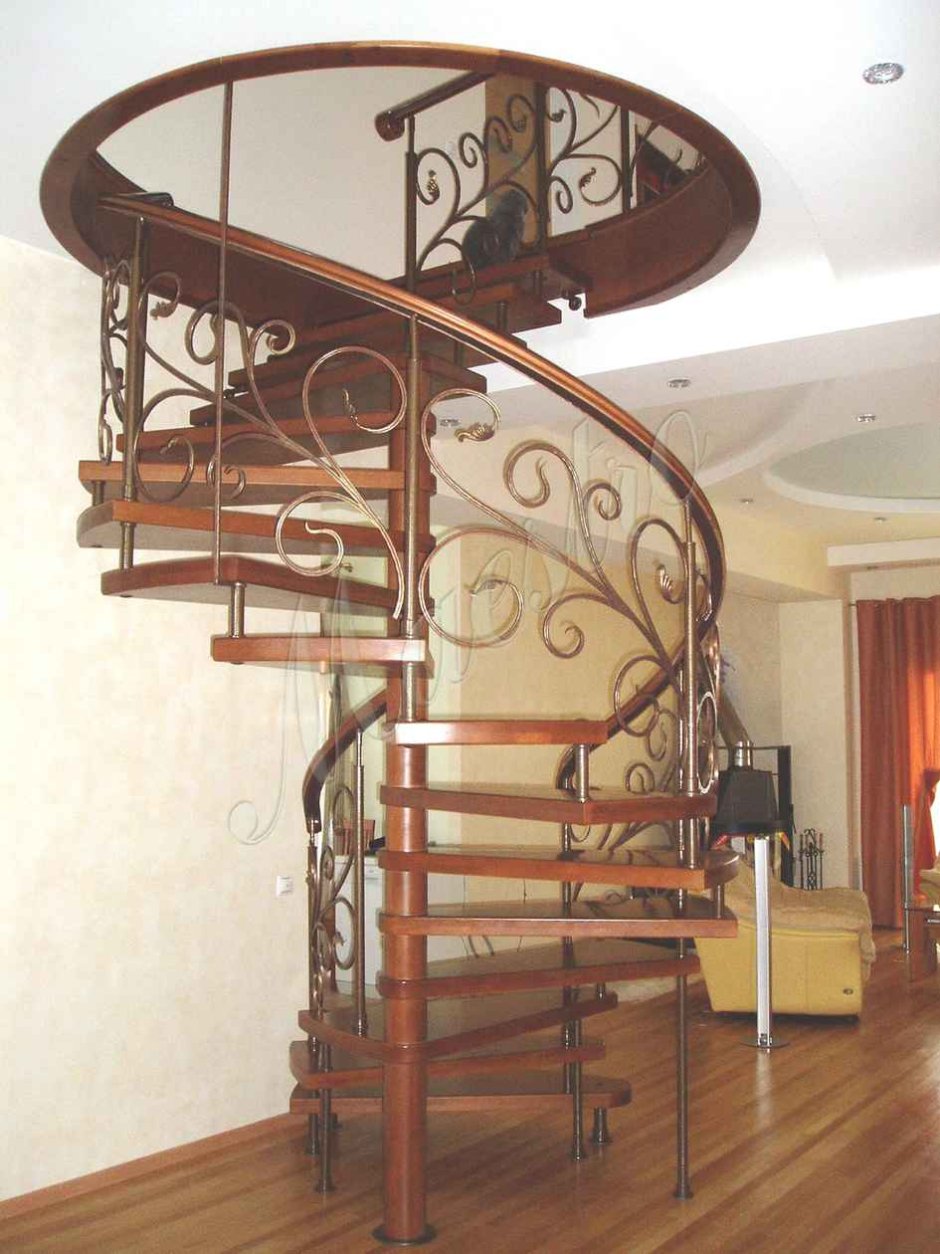 Винтовая кованая лестница с деревянными ступенями