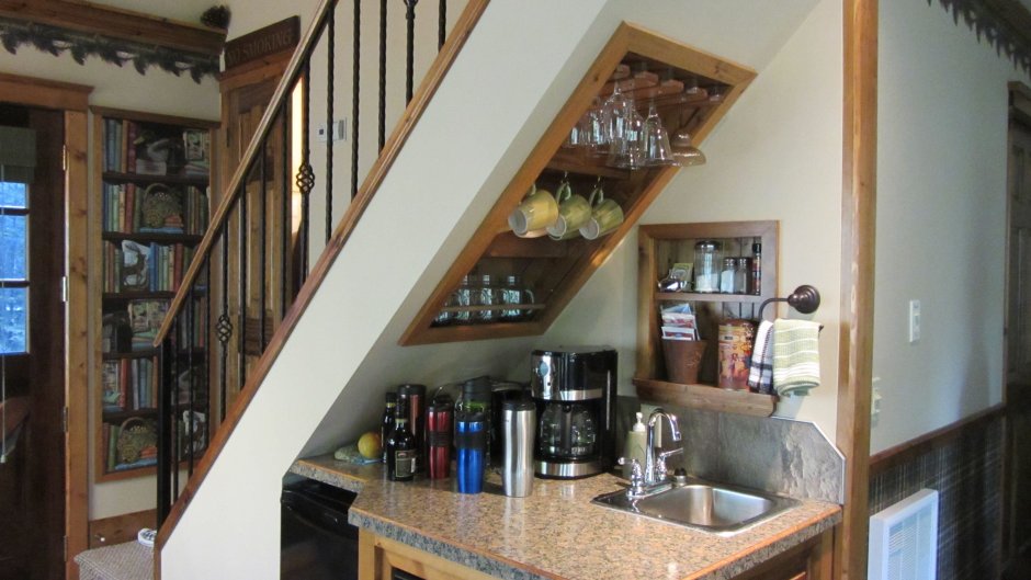 Кухонные шкафы под лестницей в деревянном доме фото