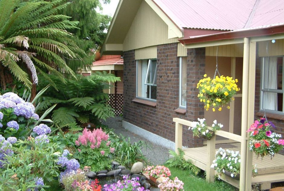 Маленький садовый домик с цветочными клумбами