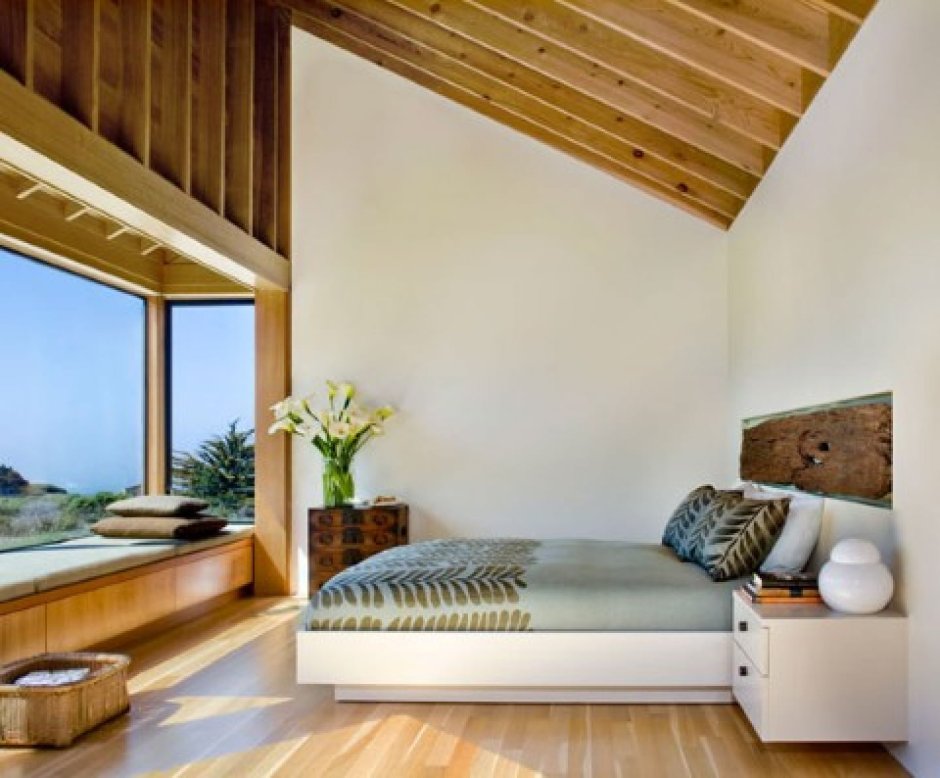 Спальня в деревянном доме с большим окном