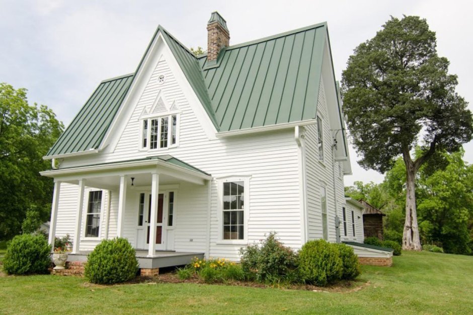 Белый домик с зеленой крышей