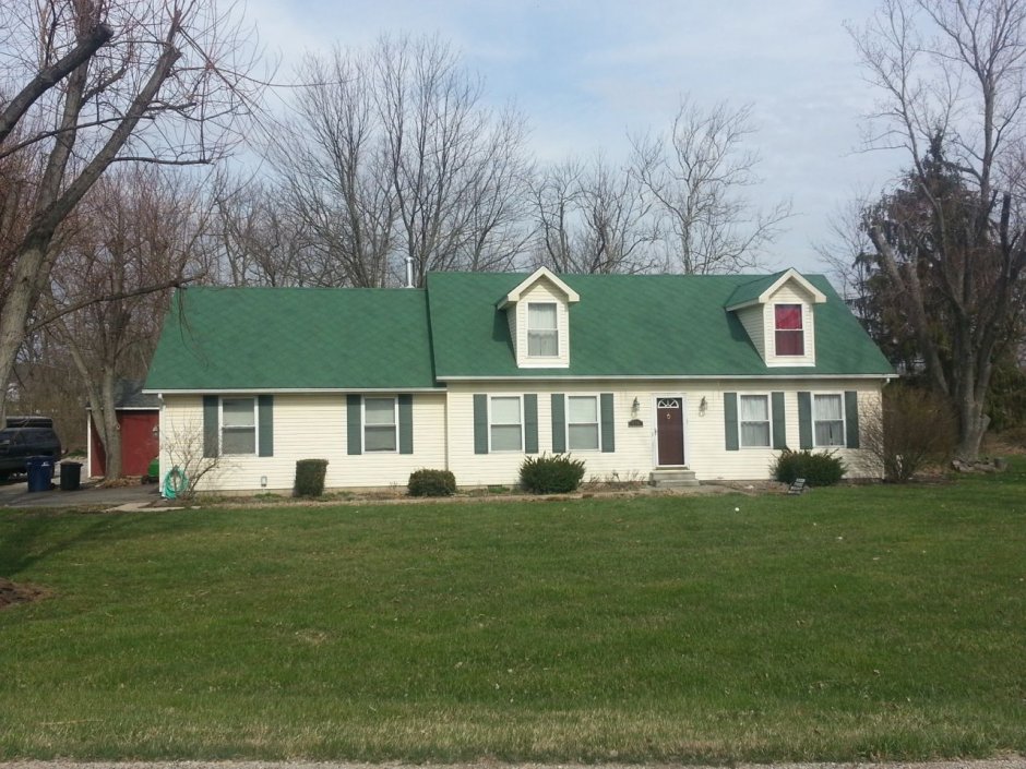 Белый дом с зеленой крышей