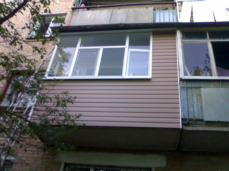 Балкон отделанный коричневым сайдингом