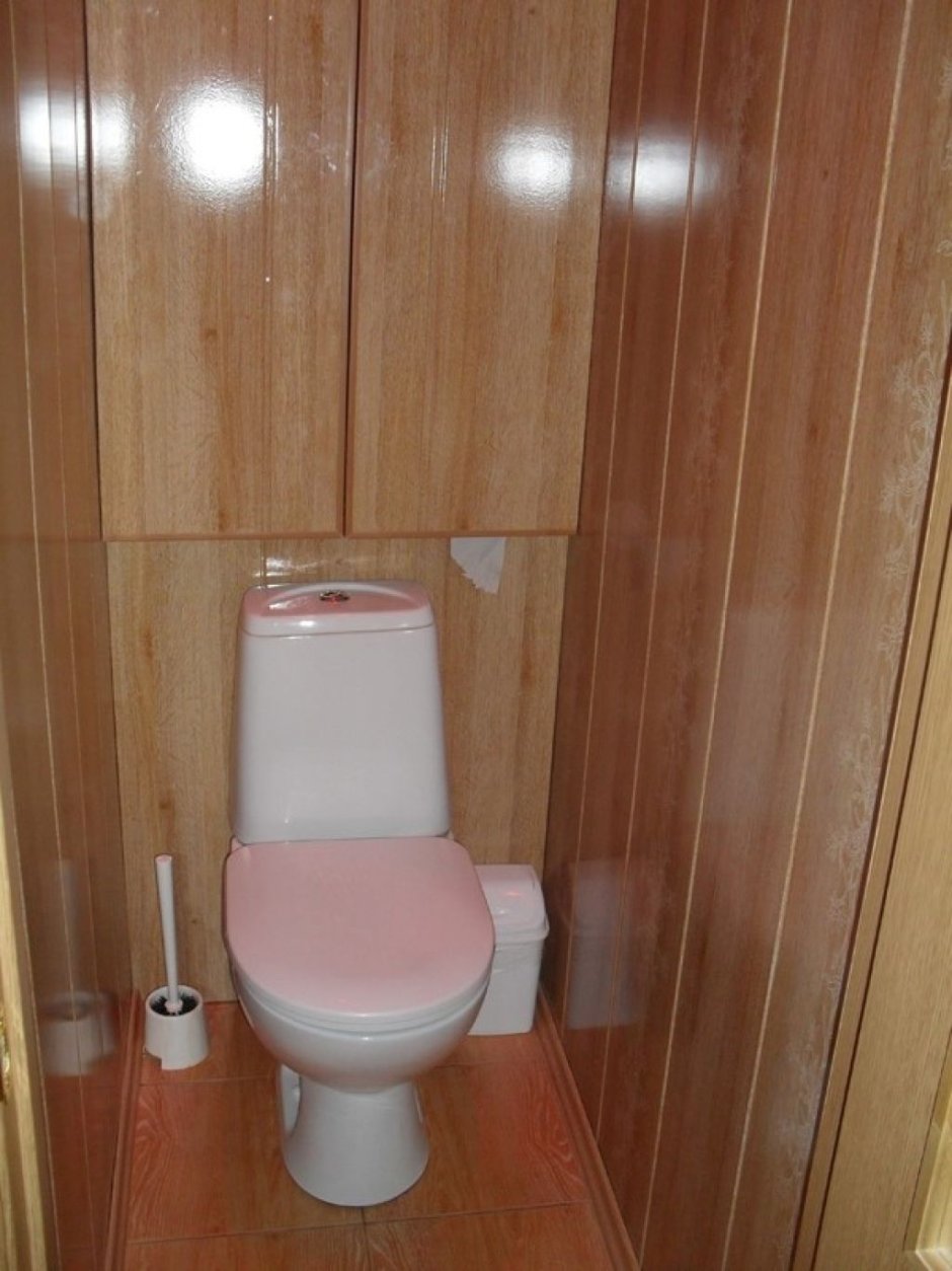 Туалет отделанный плиткой и панелями