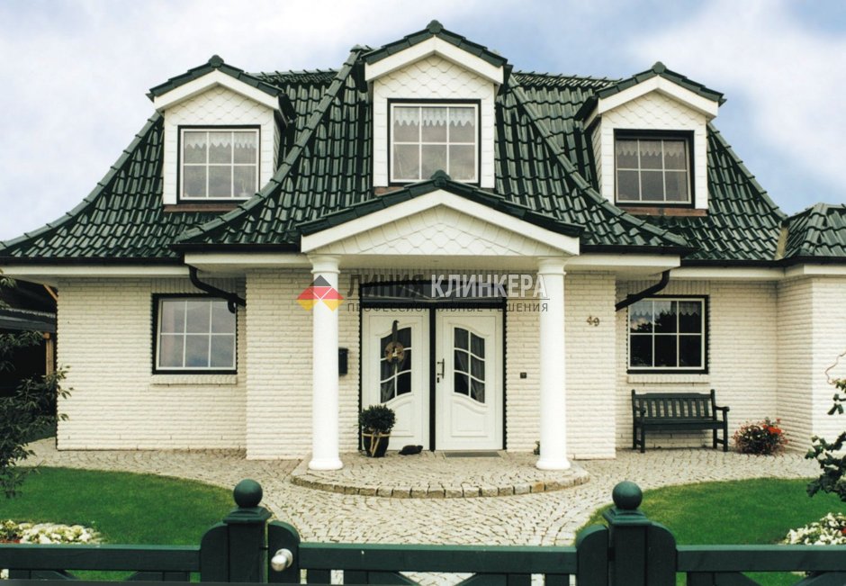 Дом из белого кирпича с зеленой крышей