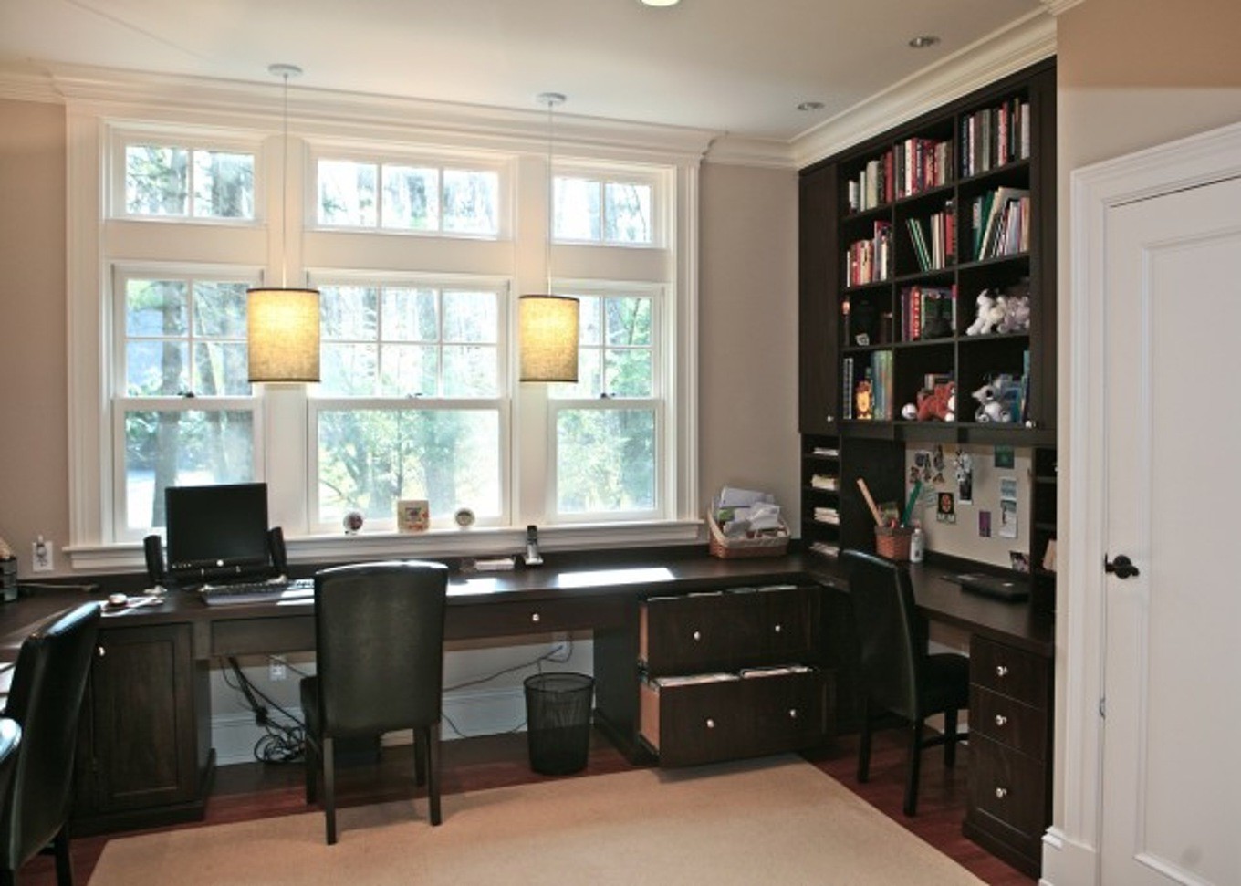 письменный стол у окна со стеллажами