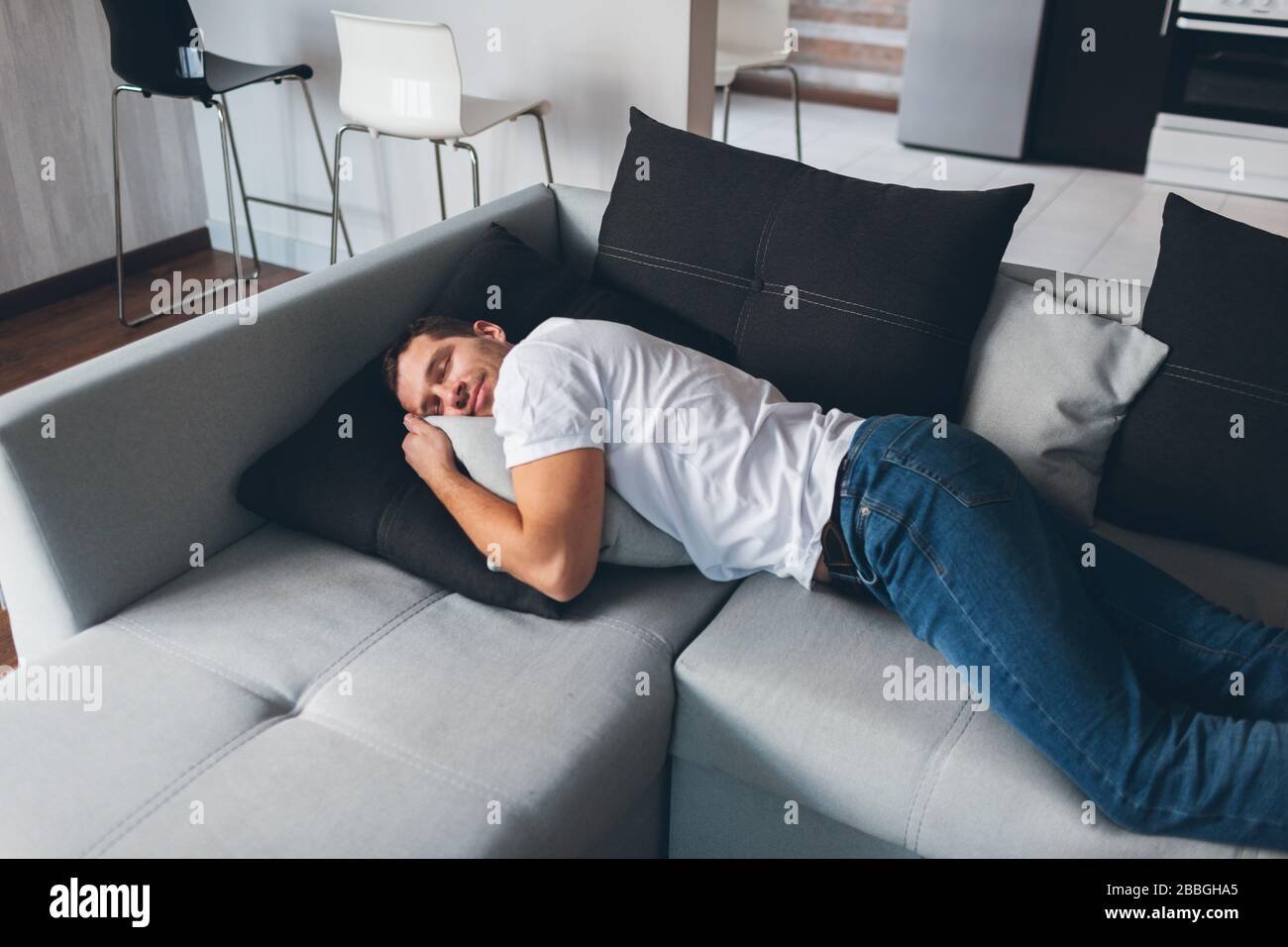 Голодный диван. Человек лежит на диване. Парень лежит на диване. Парень лежа. Спящий мужчина в джинсах.