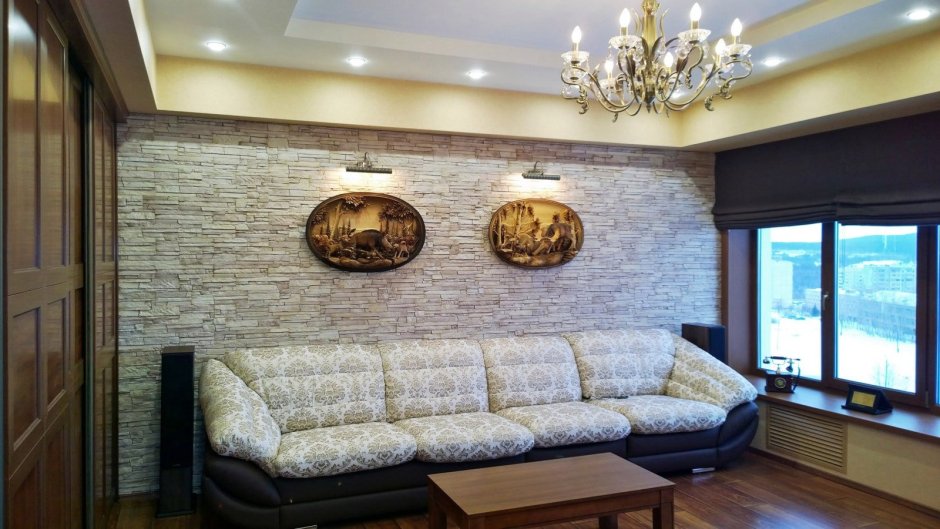 Декоративный камень в гостиной за диваном