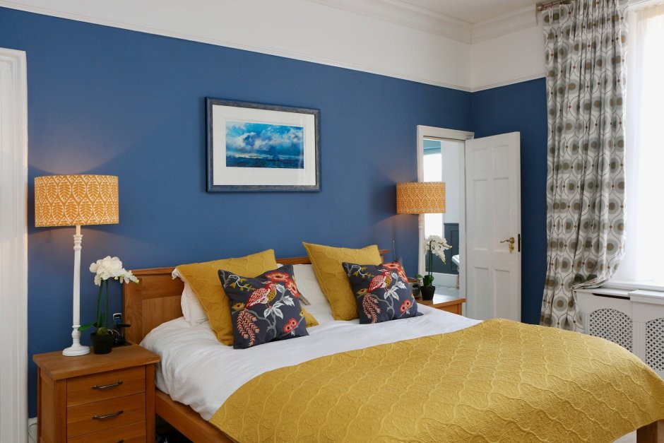 Интерьер спальни с синей стеной
