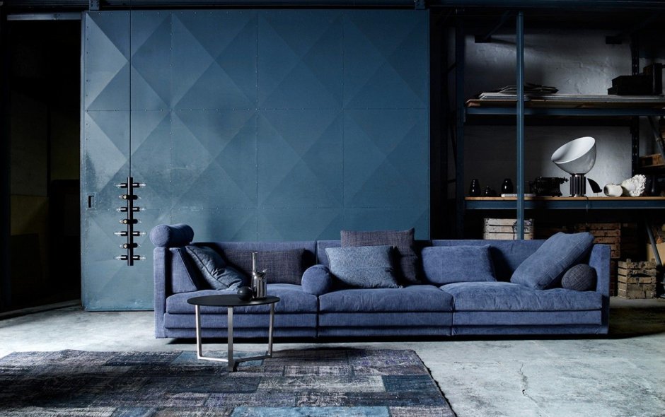 Голубой диван с кирпичной стеной