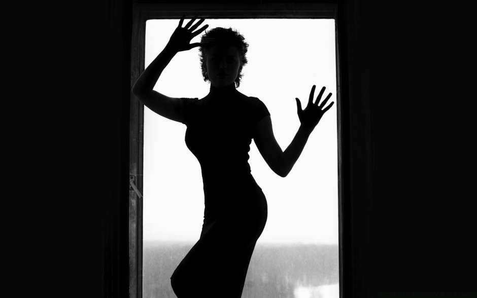 Девушка сидящая на окне в темноте