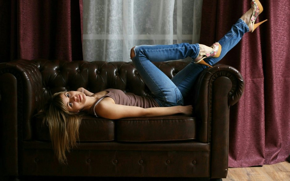 Красивая девушка лежит на диване