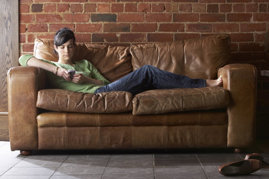 Мужик лежит на диване с телефоном