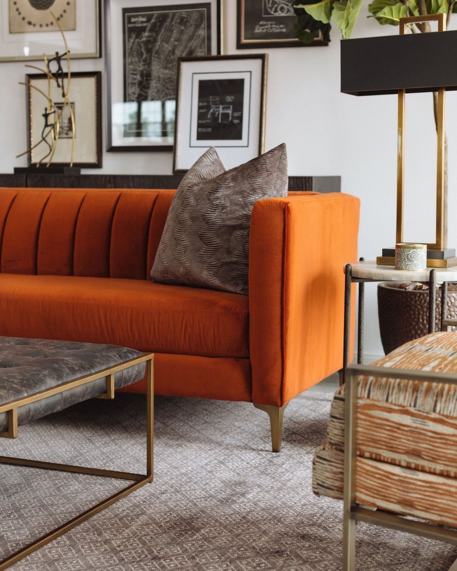 Коричневый диван с оранжевыми подушками
