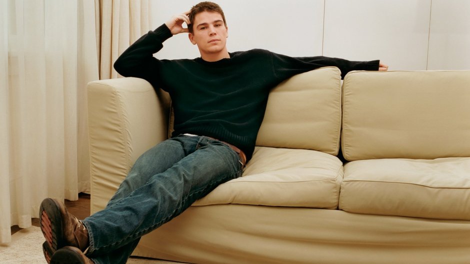 Человек расслабленно лежит на диване