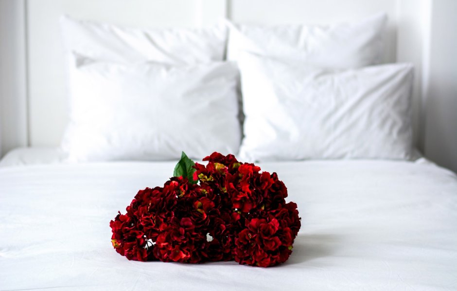 Девушка с белыми розами на кровати