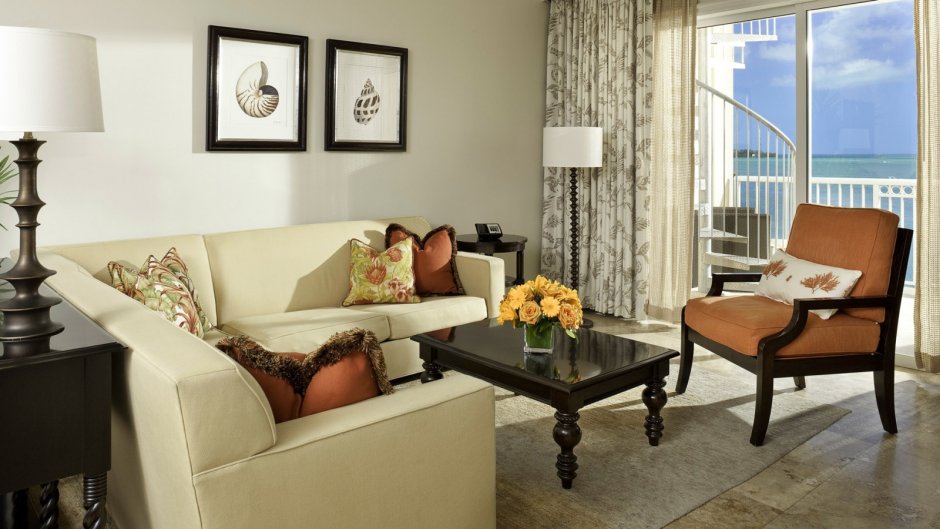 Двухместный светлый диван в интерьере с цветами