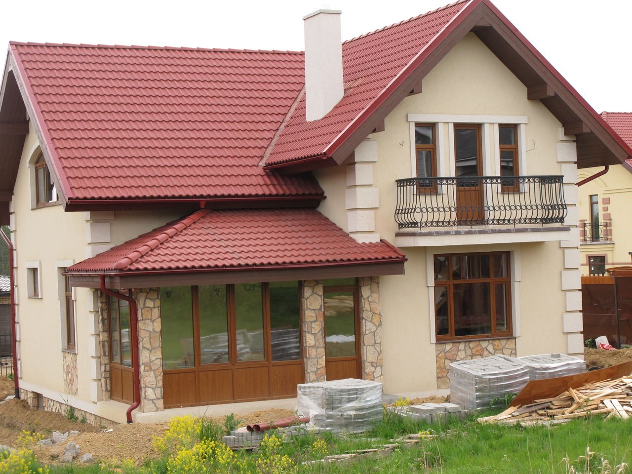 Дом с красной крышей и коричневыми окнами