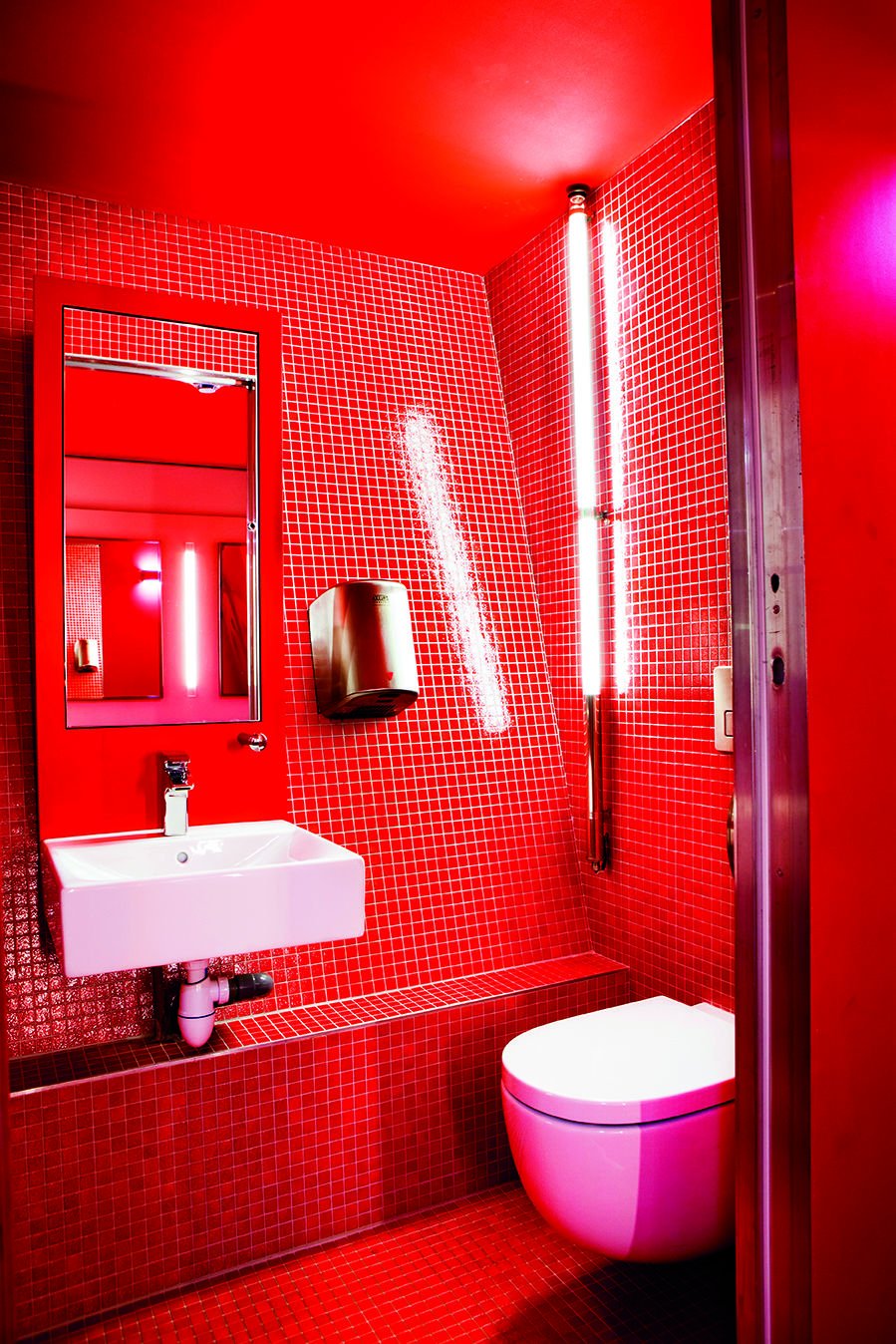 Туалетная комната с красным унитазом