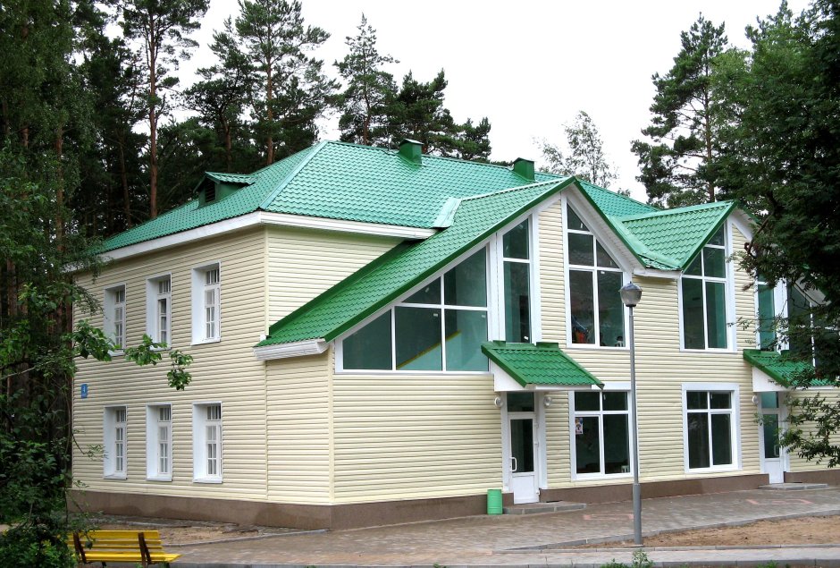 Фасады домов с зеленой крышей