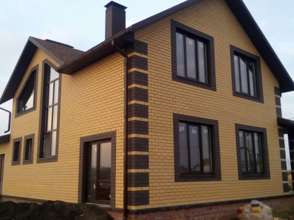 Дом из желтого кирпича с коричневой крышей