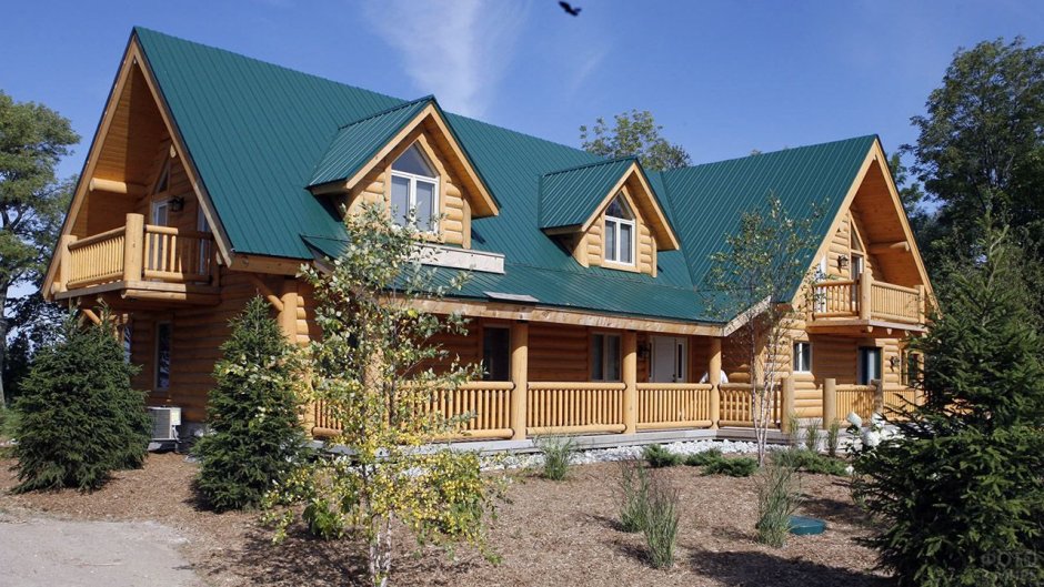 Дом из бревна с зеленой крышей