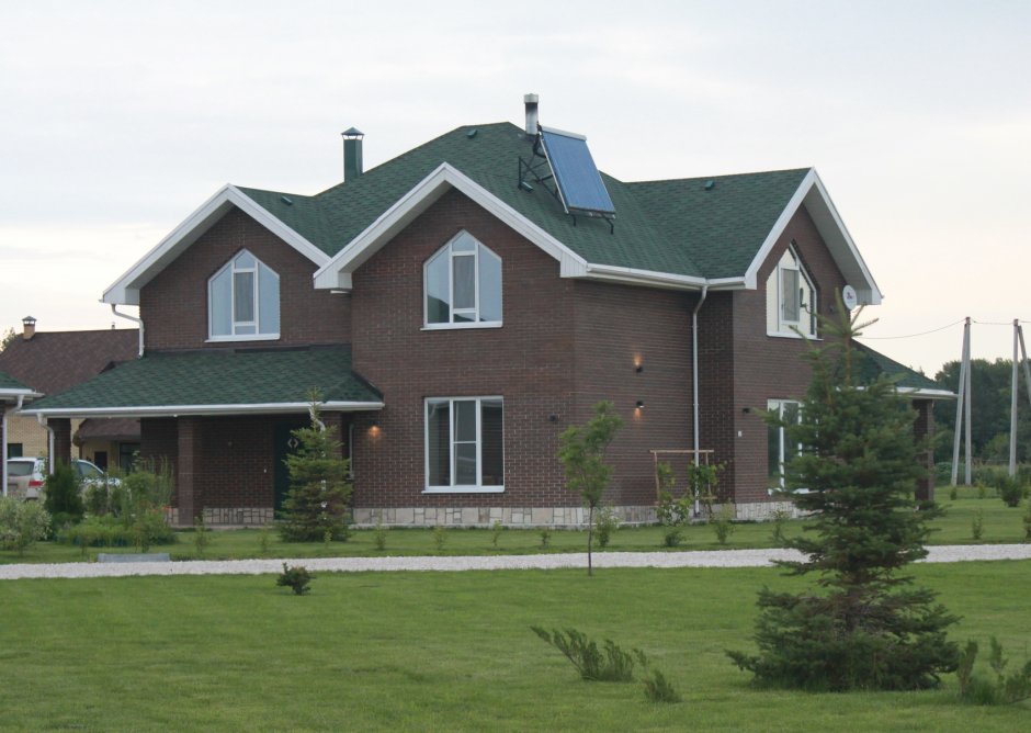Фасады домов с зеленой крышей