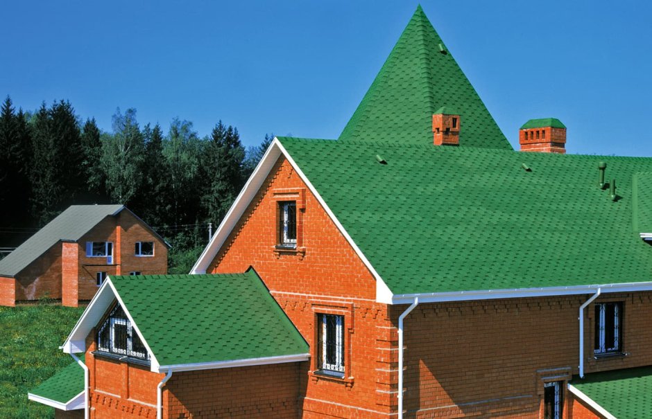 Дом из красного кирпича с зеленой крышей