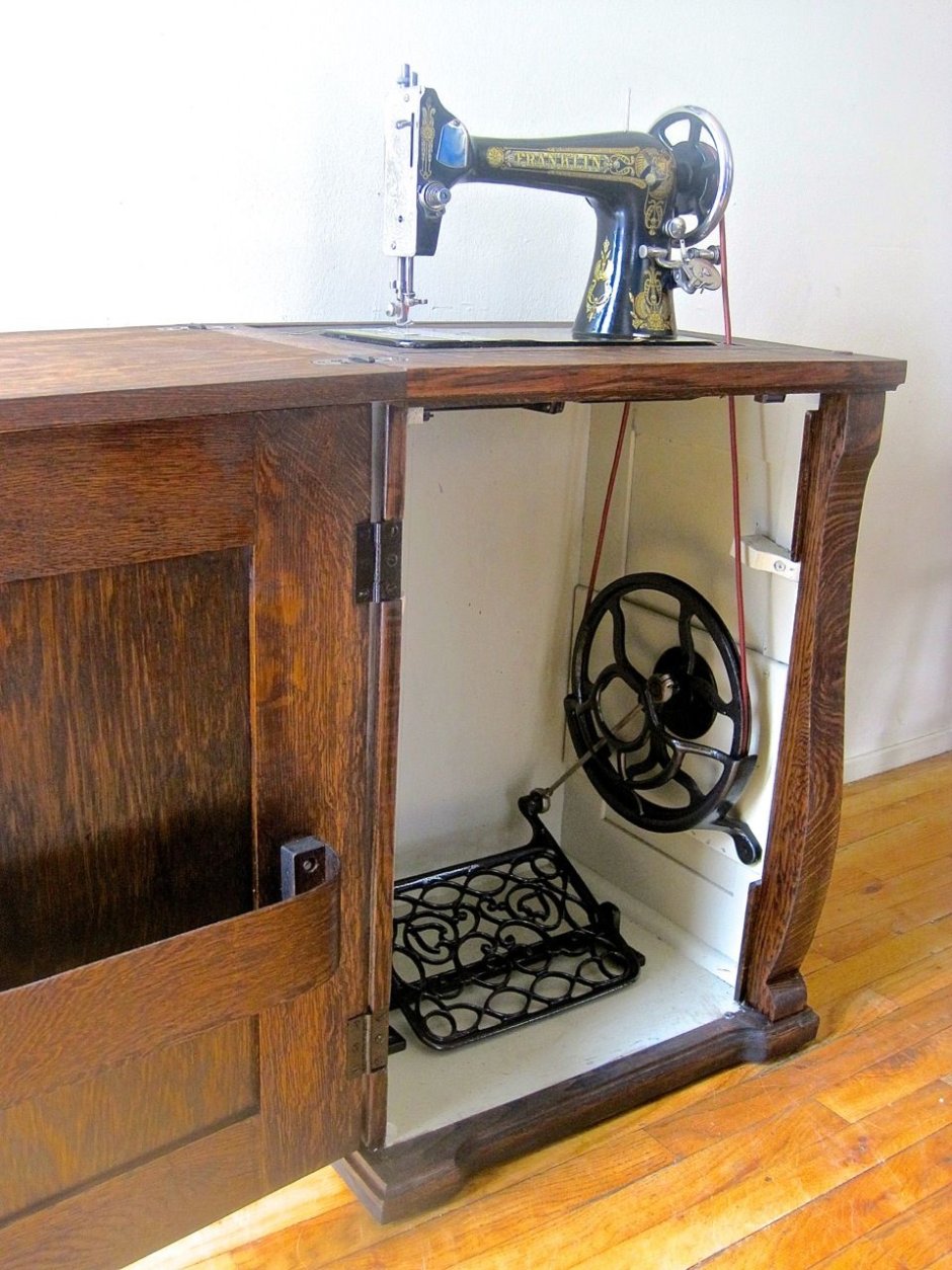Старинная швейная машинка на тумбочке