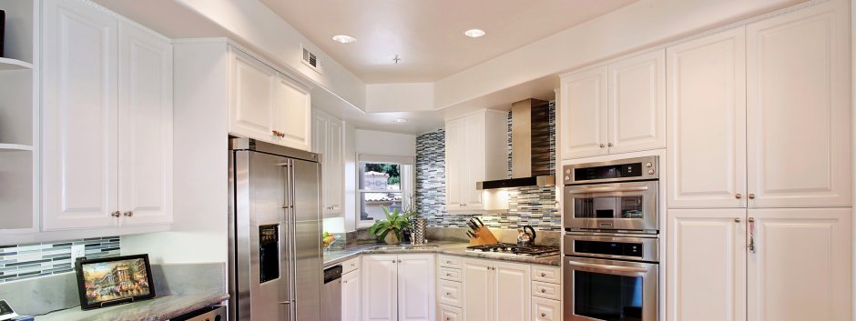 Золотой холодильник в интерьере с белой кухней
