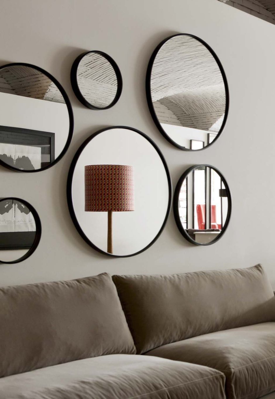 Круглое зеркало над диваном