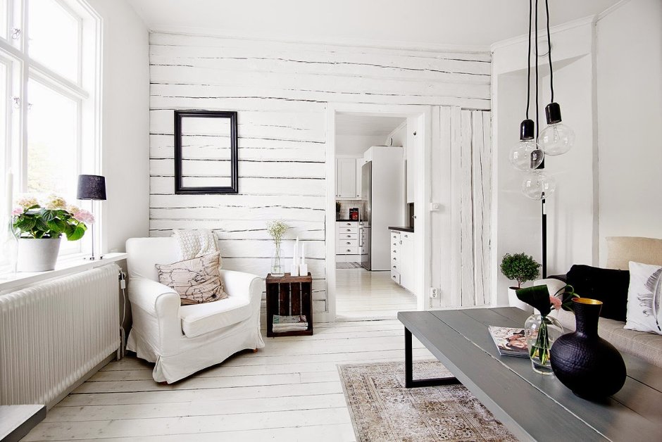 Интерьер гостиной с белыми стенами и деревянным полом