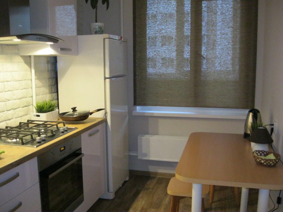 Маленькая кухня с холодильником у окна