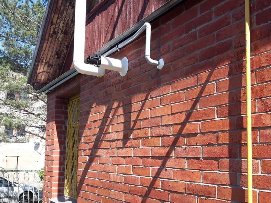 Вентиляционная труба на фасаде частного дома