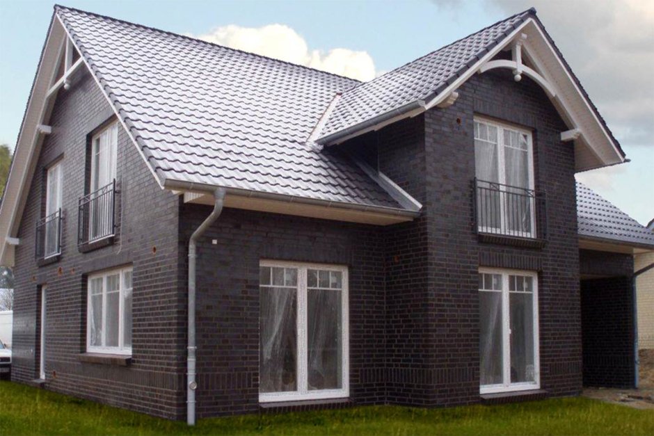 Дом из серого кирпича с белыми окнами