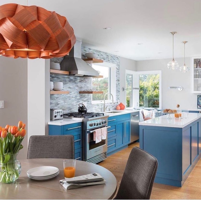 Синяя кухня с оранжевыми стульями