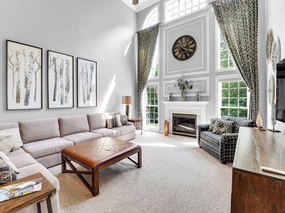 Часы над диваном в интерьере гостиной