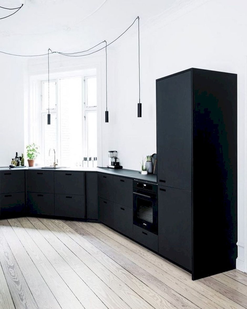 Черный матовый холодильник на кухне белой