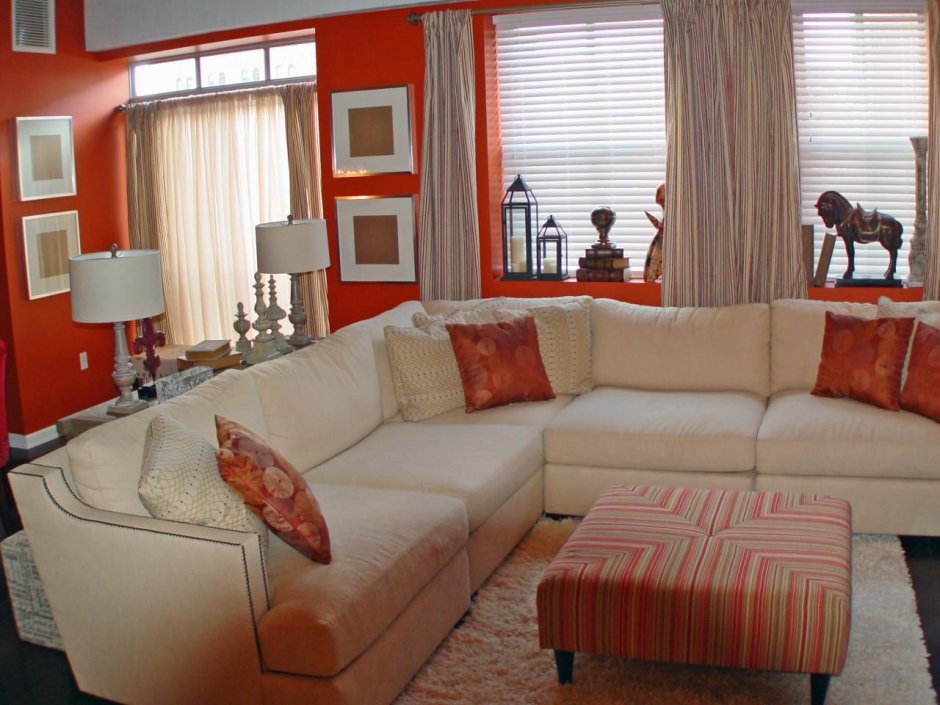Интерьер большой комнаты с оранжевым диваном