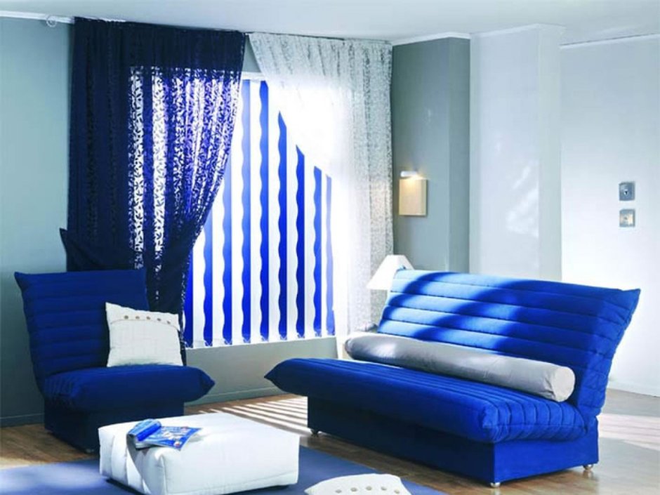 Синие шторы в гостиной с коричневым диваном